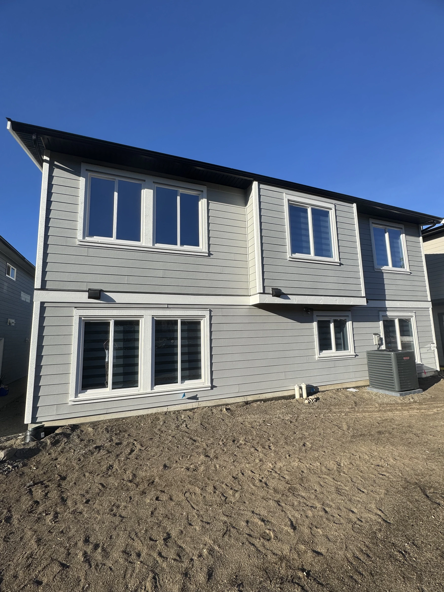 New-construction home exterior with completed siding and trim painting