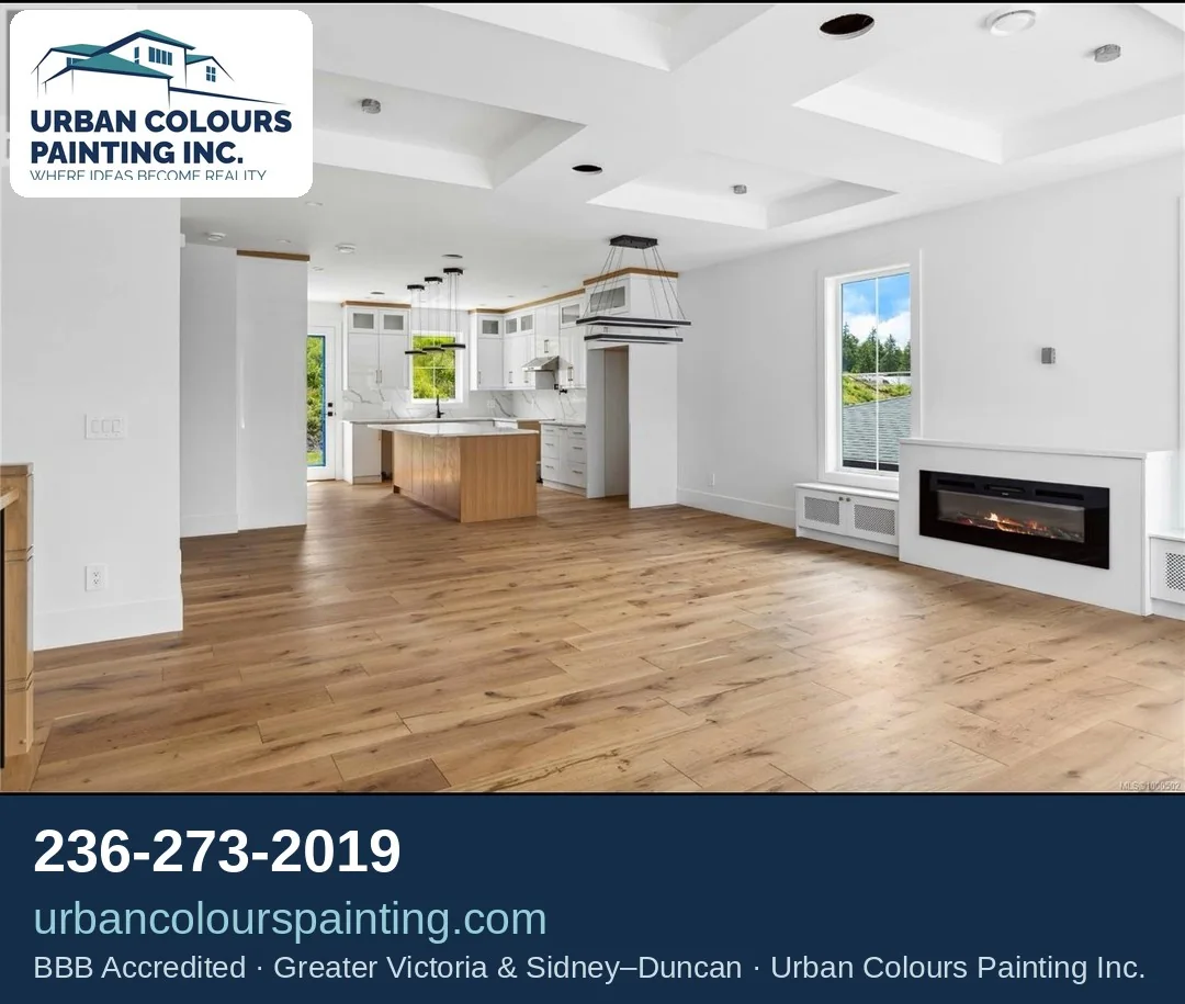 Finished open-plan living room and kitchen with light painted walls in Greater Victoria