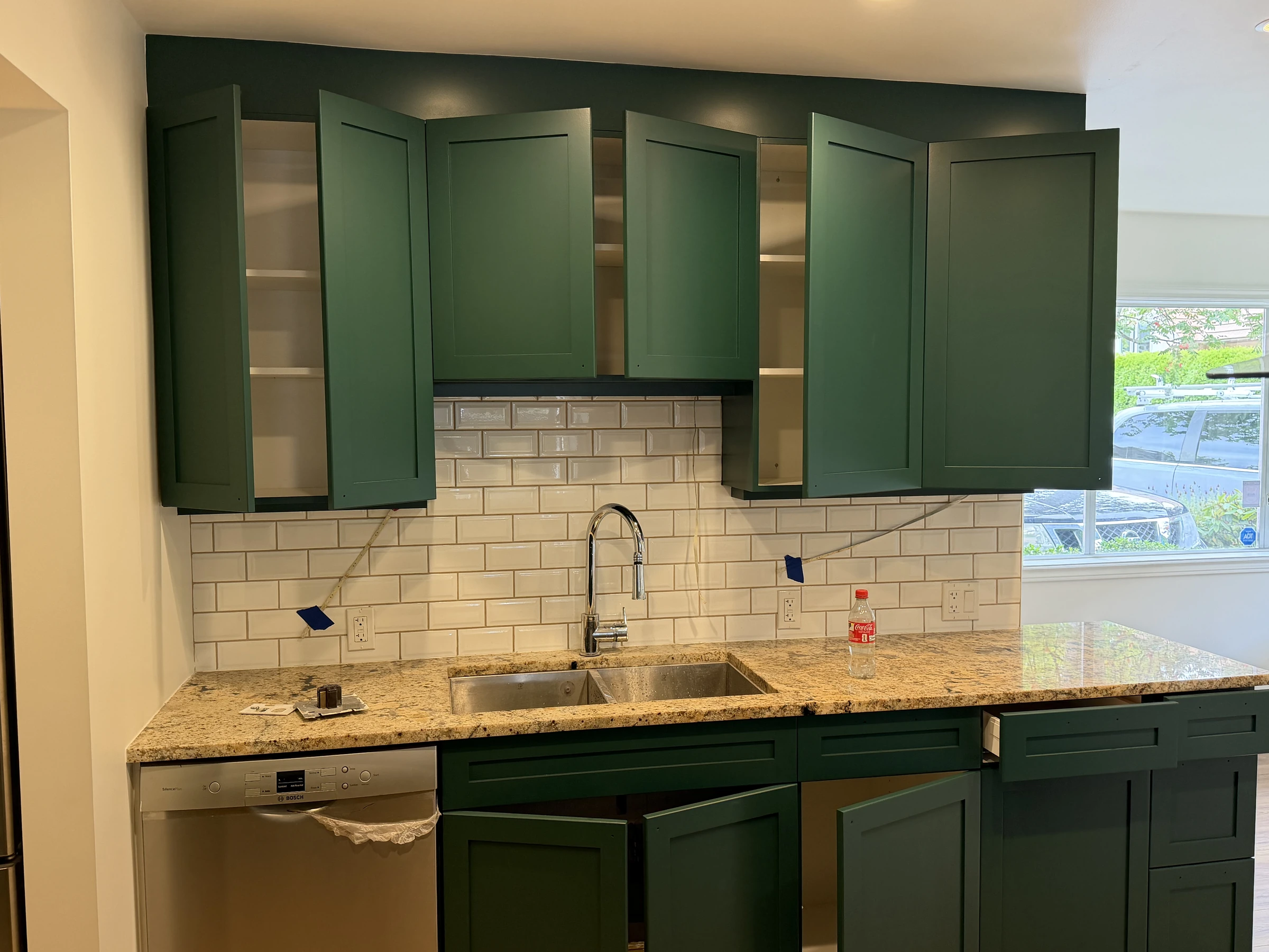 Finished deep green kitchen cabinets with sink, backsplash and countertop